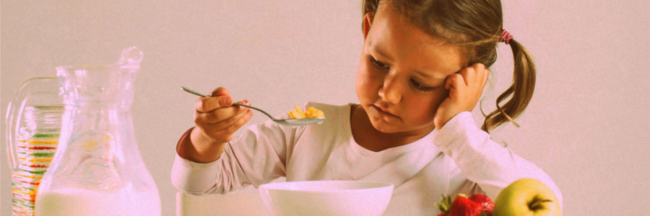 Little girl looking distastefully at cereal bowl