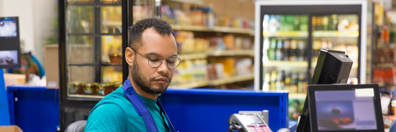 African American cashier scanning goods at checkout