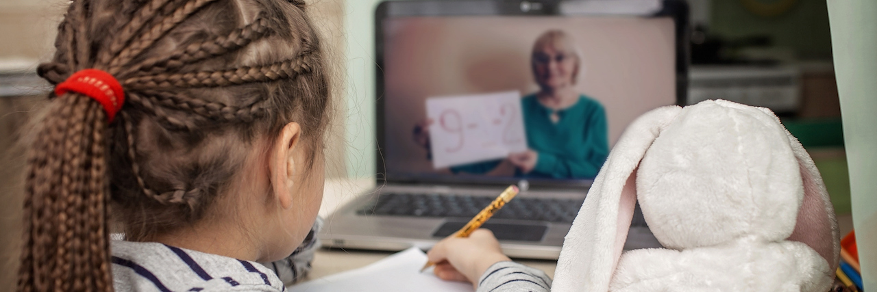 An Example of a Virtual Second Grade Classroom During COVID-19 A young girl using a laptop for virtual learning