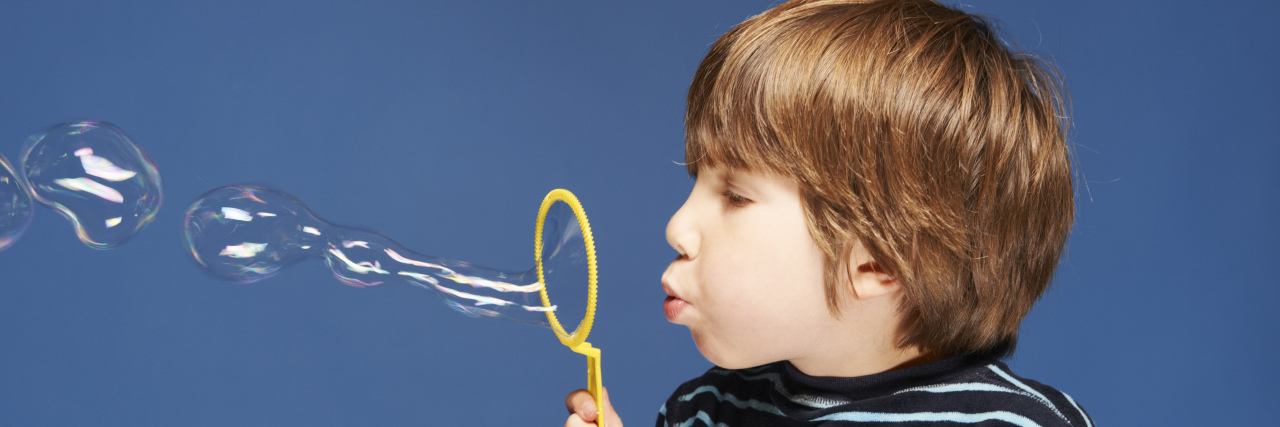 Autism and Saliva Obsession Amid the Coronavirus Pandemic Close up of boy blowing bubbles