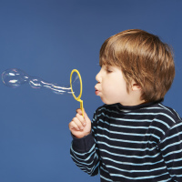 Close up of boy blowing bubbles