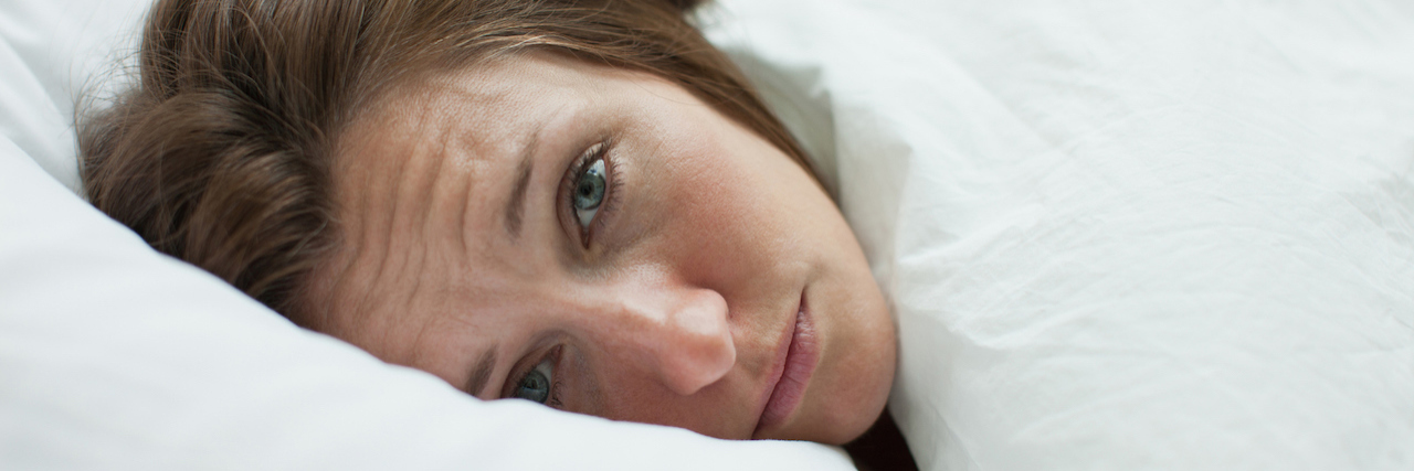 I Think I Have COVID-19, but My Doctor Said She Couldn't Test Me A woman lying in bed