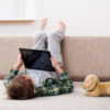 Boy playing with tablet on sofa.