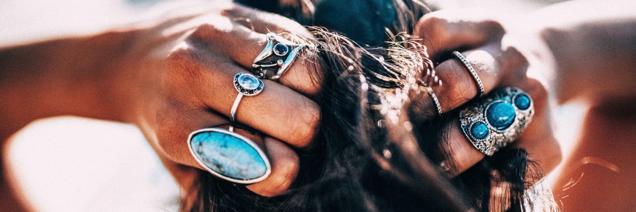 Why I'm Dressing Up During the Coronavirus Shutdown Woman with bohemian style jewelry rings on hands.