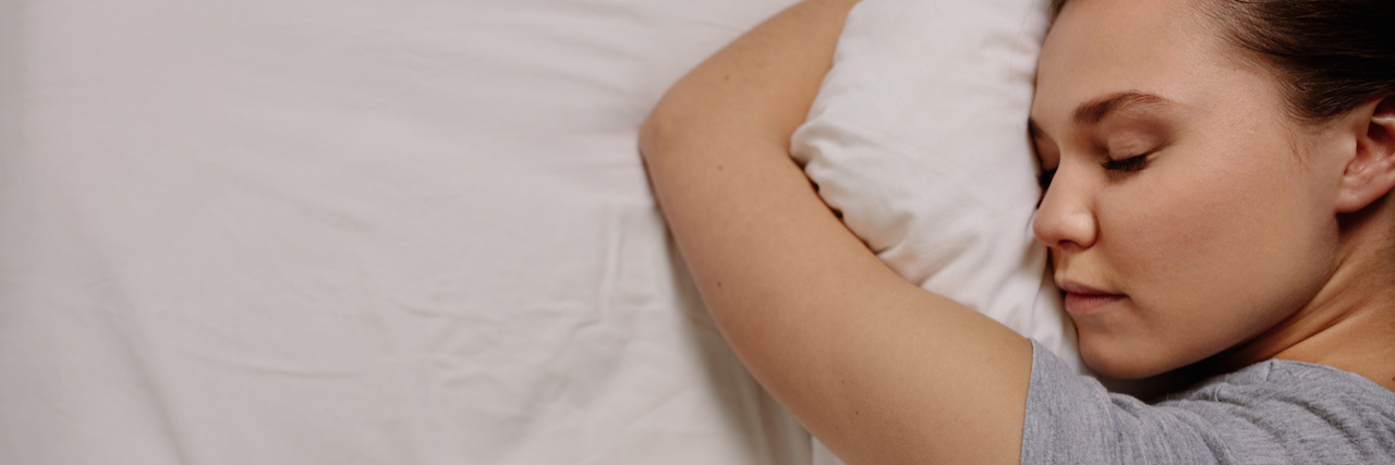 How the COVID-19 Pandemic Is Helping One Mom With Depression A woman lying in bed, hugging her pillow