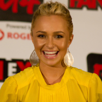 Hayden Panettiere smiles at an event in a yellow outfit
