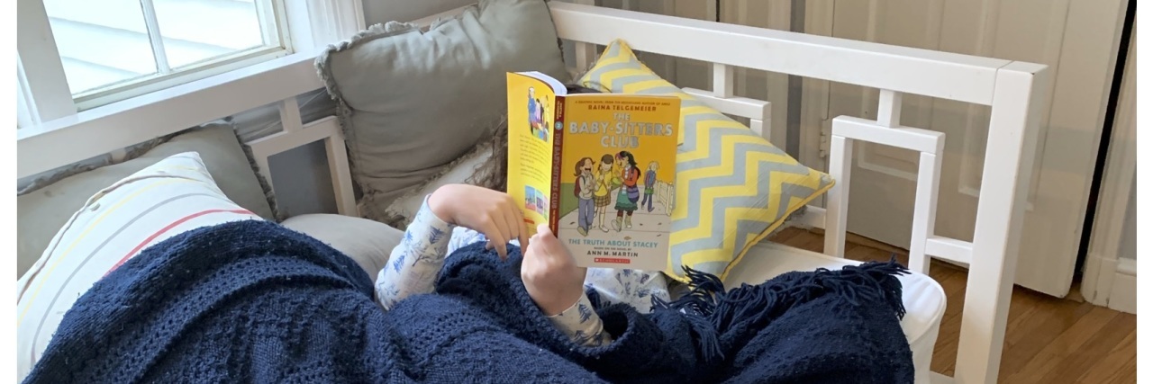 Rebecca's daughter reading in bed.