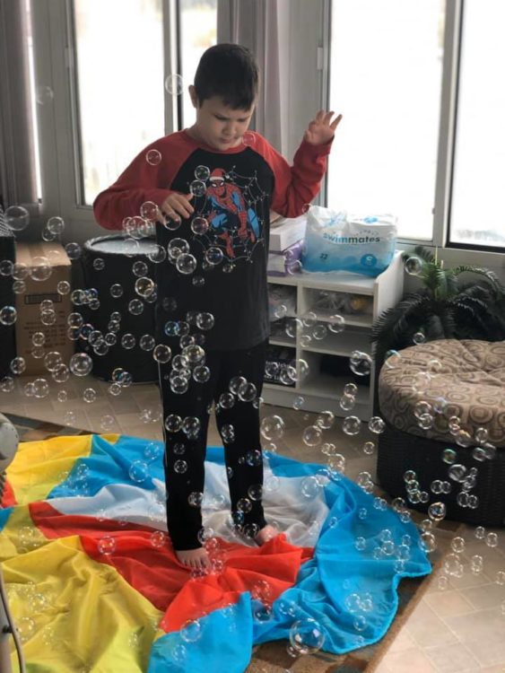 boy playing with bubbles in the house