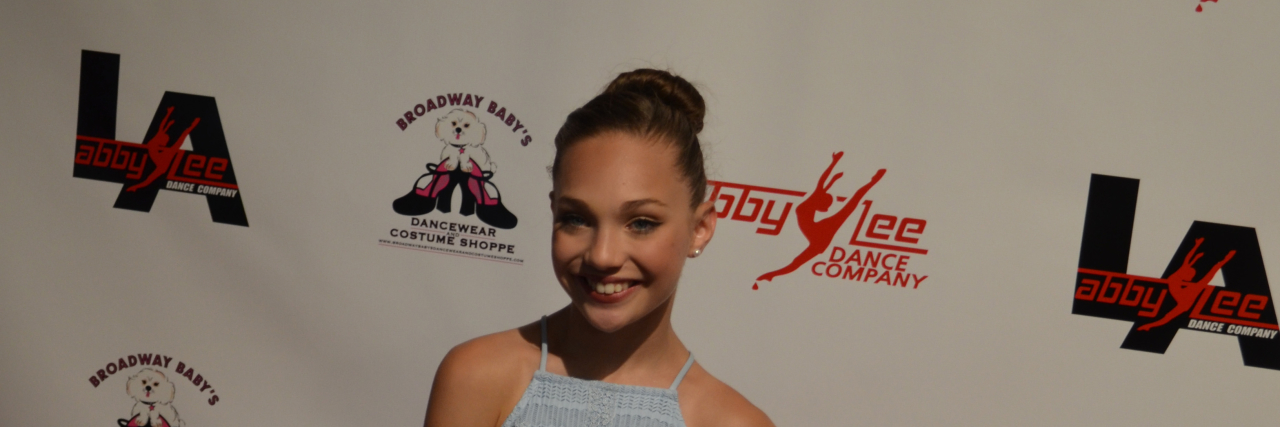 Maddie Ziegler poses in a blue dress on the red carpet