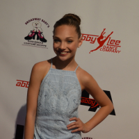 Maddie Ziegler poses in a blue dress on the red carpet