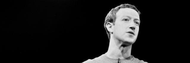 A black and white photo of Mark Zuckerberg speaking onstage
