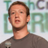Mark Zuckerberg speaks onstage and is holding a microphone