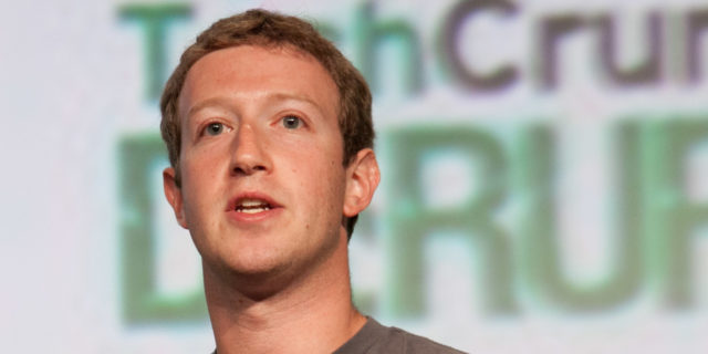 Mark Zuckerberg speaks onstage and is holding a microphone