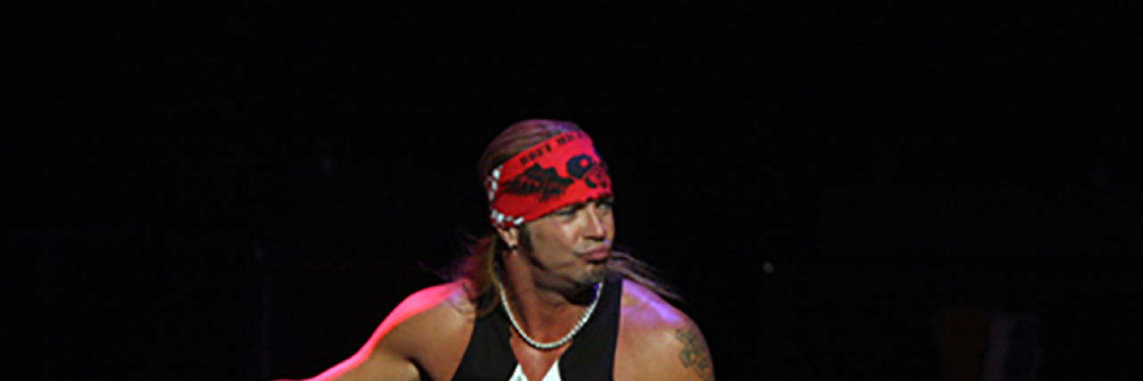 Bret Michaels dances onstage at his concert with his mic outstretched