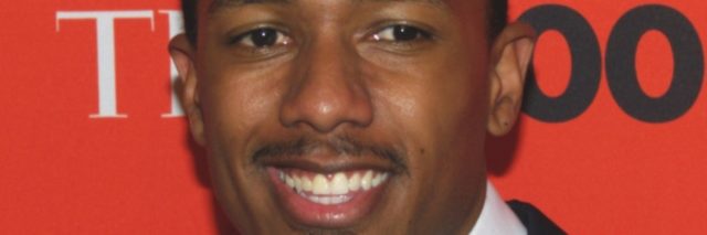 Nick Cannon smiles while posing for the red carpet