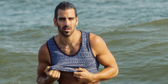 Nyle DiMarco models for the camera in the ocean at a beach
