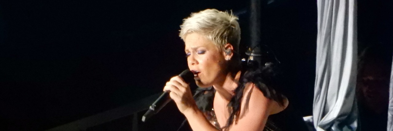 Pink performs on stage in a black dress