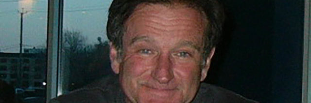 Robin Williams poses for a photo at a bar