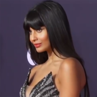 Jameela Jamil is on the red carpet and is wearing silver and black sparkly dress