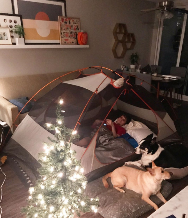 man in tent in living room