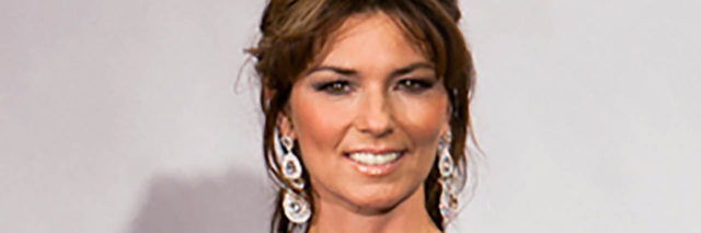 Shania Twain holds a Juno while wearing a black and white outfit