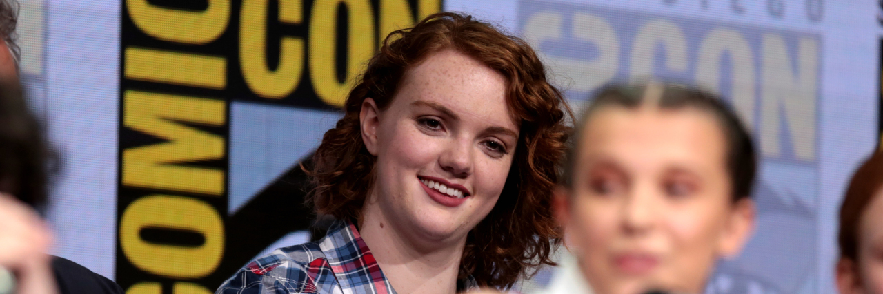 Shannon Purser smiles at a panel for Stranger Things