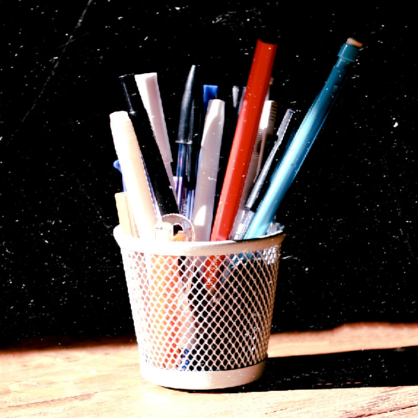 A rustic image of a pencil cup holder with multiple writing utensils: pens, mechanical pencils, markers.
