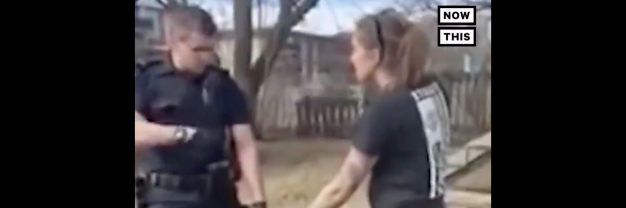 Viral Video Shows Police Officer Detaining a Woman's Service Dog police officer holding woman's service dog