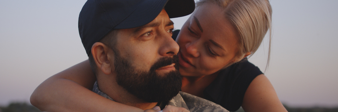 How to Help a Veteran With PTSD and Depression, Substance Abuse A woman with her arms around a man in a military uniform