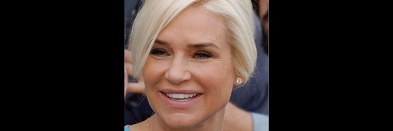 Yolanda Hadid in a blue outfit smiles at a red carpet event
