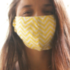 photo of woman wearing yellow face mask and smiling with her eyes, looking into camera