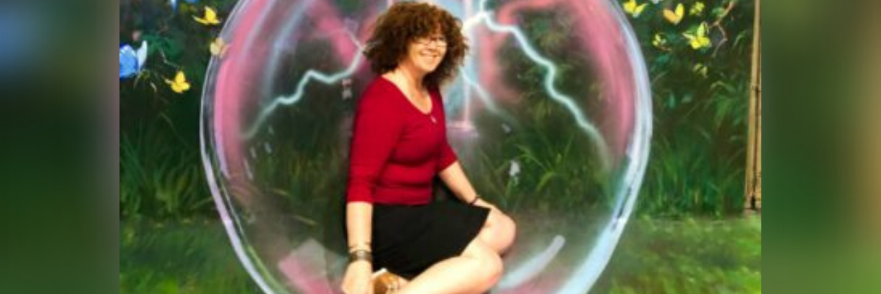 author in red shirt and black skirt sitting with an animated bubble around her