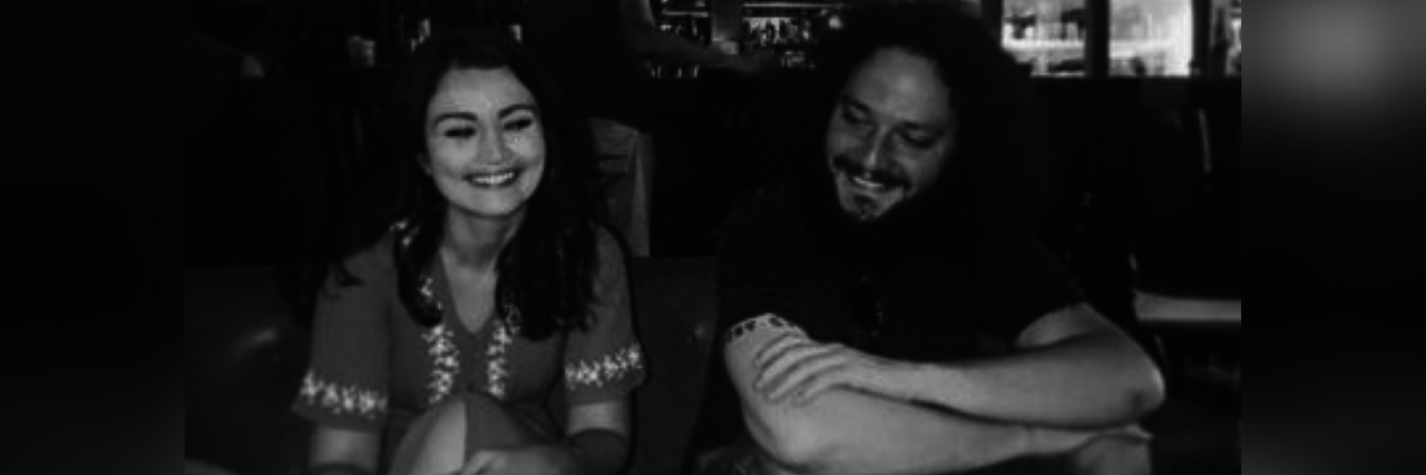 photo of author and boyfriend sitting next to each other smiling