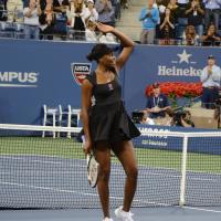 Venus Williams waves at the crowd from the tennis court