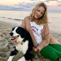 Elizabeth Wurtzel sits at a beach with her dog