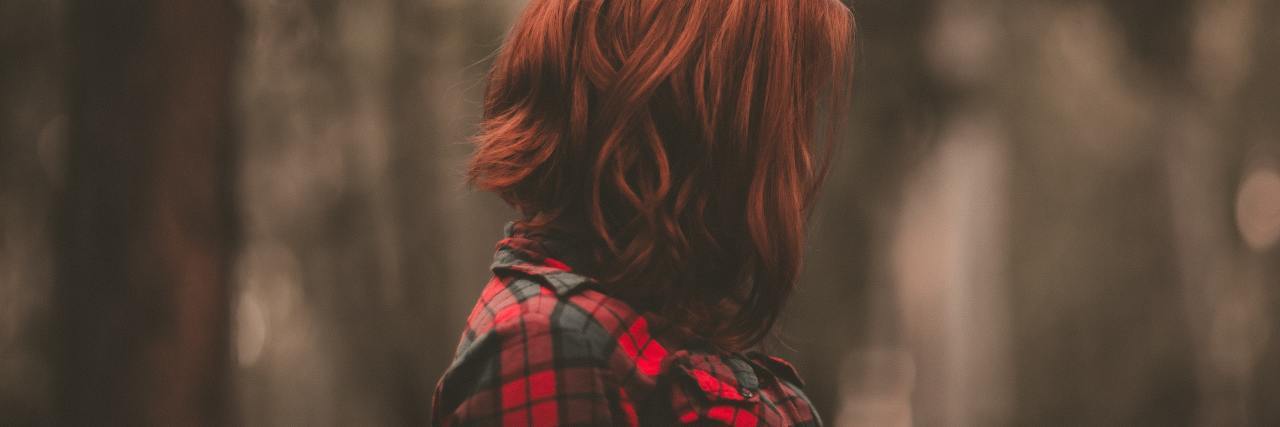 What Someone With an Invisible Illness Wants You to Know photo of woman with red hair in profile view with hair covering her face