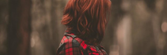 photo of woman with red hair in profile view with hair covering her face