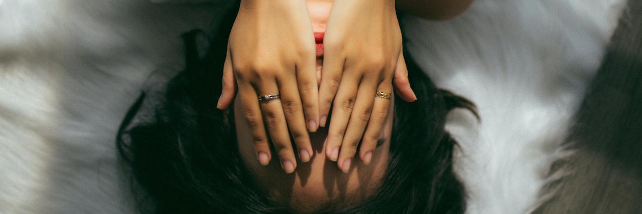 Borderline Personality Disorder: Missing Favorite Person in COVID-19 A woman lying in bed, covering her hands with her face
