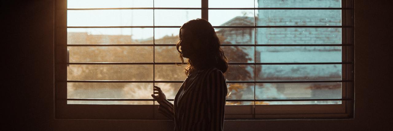 photo of woman silhouetted against city window