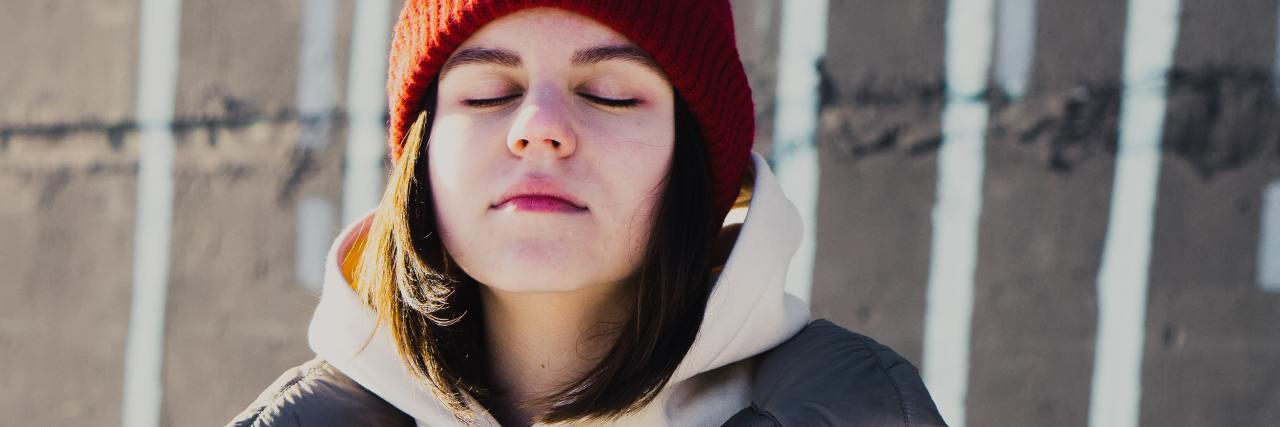 What to Know: Eating Disorders and Waiting on College Acceptances photo of young woman in heavy coat and red hat with eyes closed and face raised