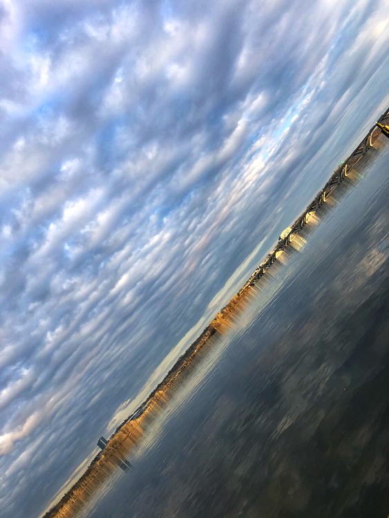 Slanted photo of the horizon with beautiful clouds over a body of water