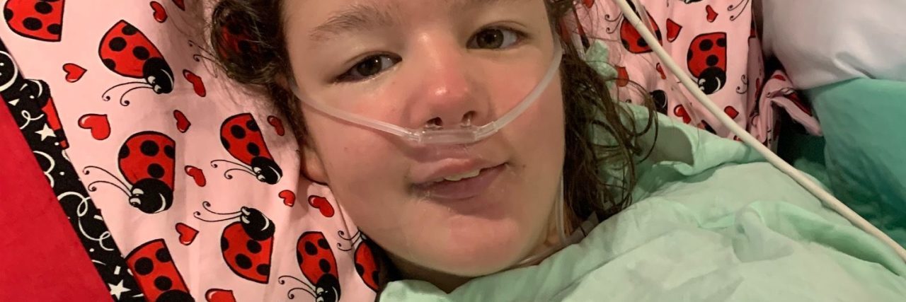 What to Know If Your Medically Fragile Child Might Have COVID-19 photo of contributor's child Marie lying on hospital bed with nasal cannula