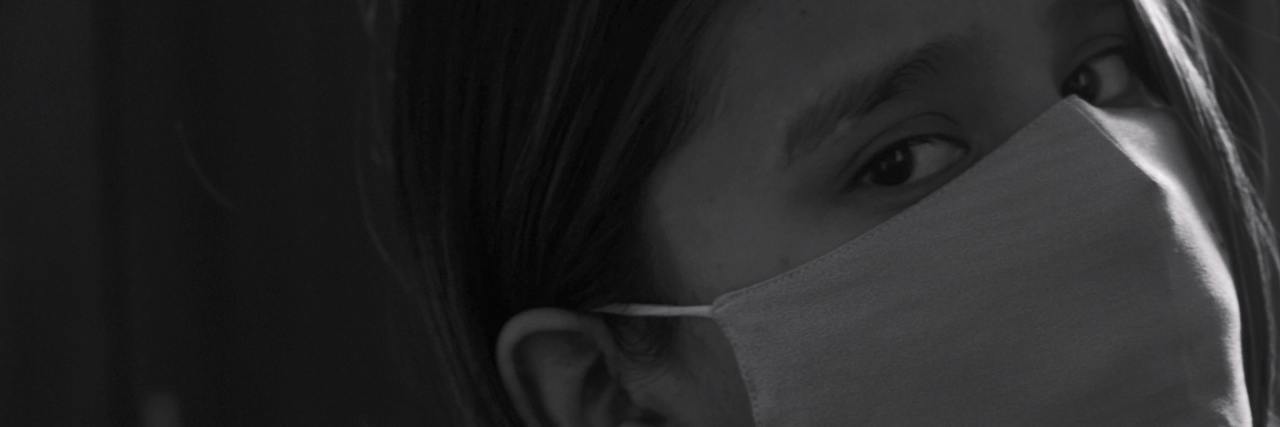 Thanking Mental Health Workers During the Coronavirus Pandemic black and white photo of woman looking over shoulder and wearing face mask