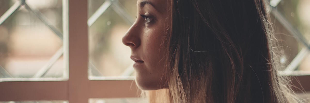 A woman standing in front of a window