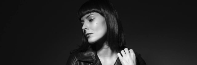 black and white photo of a woman in a leather jacket looking away