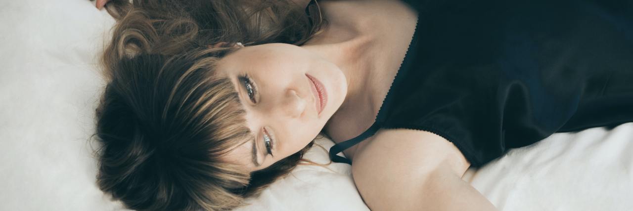 Allowing Myself to Rest and Say No Helped My Anxiety woman lying in a bed looking away