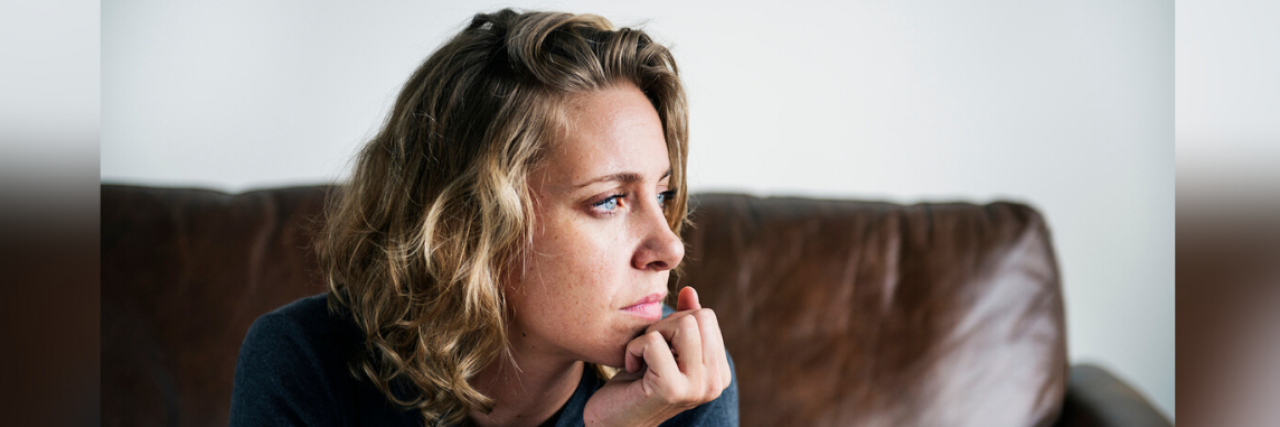 Finding Relief from Chronic Pain — Lessons From an Expert Woman on couch, looking away from camera