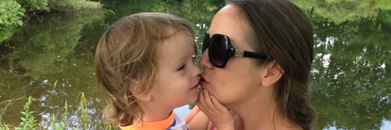 Visualizing and Modeling a Positive Future for Your Child With Autism Kate hugging her son by a lake.