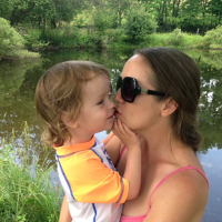 Kate hugging her son by a lake.