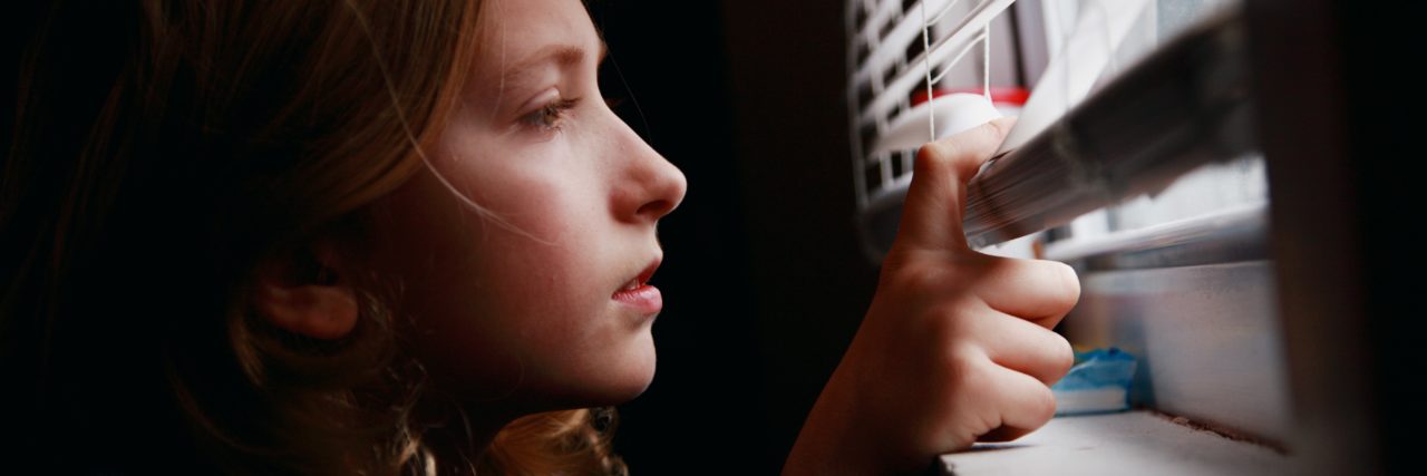 Coping With COVID-19 Restrictions as a Person With Cerebral Palsy Woman looking out a window.